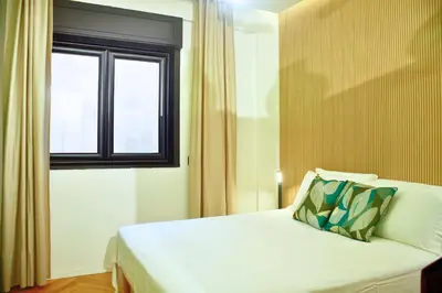 a bedroom with a white bed with a window at Plaza Suite in Palermo