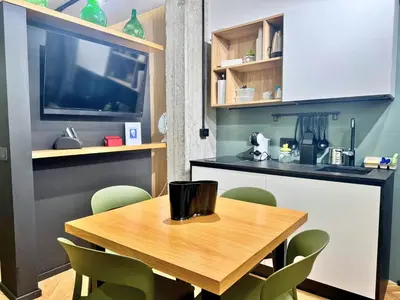 a kitchen with a wooden table and green chairs at Plaza Suite in Palermo