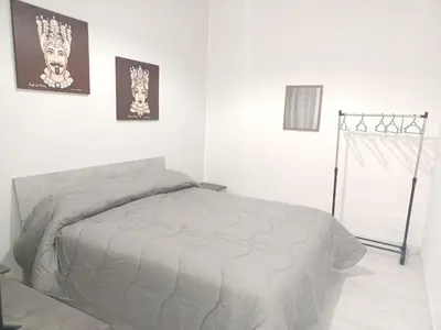 a bedroom with a bed in a white room at La casa di gabry in Palermo