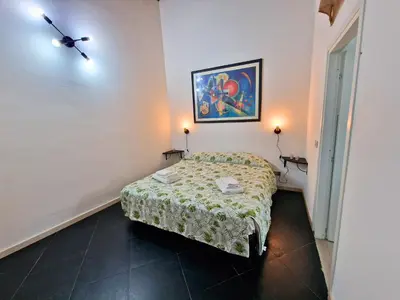 a small bedroom with a bed and a painting on the wall at Cattedrale - Maiolica Brugnò in Palermo