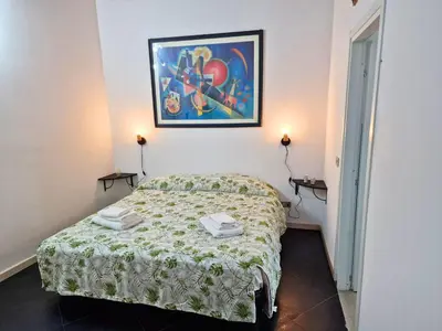 a bedroom with a bed and a painting on the wall at Cattedrale - Maiolica Brugnò in Palermo
