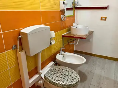 a bathroom with a toilet and a sink at Orange Lemon Business Palermo in Palermo