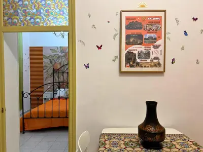 a vase on a table in a room with butterflies on the wall at Orange Lemon Business Palermo in Palermo