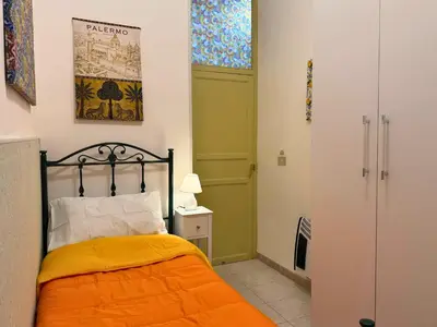 a bedroom with a bed with an orange blanket at Orange Lemon Business Palermo in Palermo