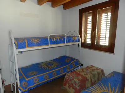a room with two bunk beds and a window at Casetta Rosina in Scopello