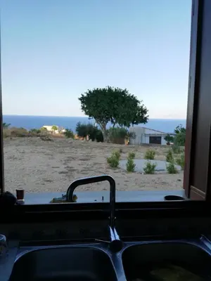 a kitchen sink with a view of the ocean at Casetta Rosina in Scopello
