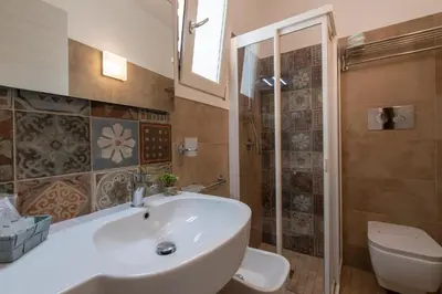 a bathroom with a white sink and a toilet at La Nicchia in San Vito lo Capo