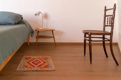 a bedroom with a bed and a chair and a rug at Summaq Terrace in Palermo