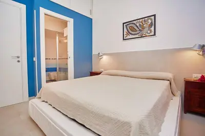 a bedroom with a bed and a blue wall at Villa Pandora in Scopello
