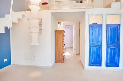 a hallway with blue doors and white walls at Villa Pandora in Scopello