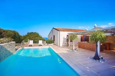 a swimming pool in front of a house at Villa Pandora in Scopello