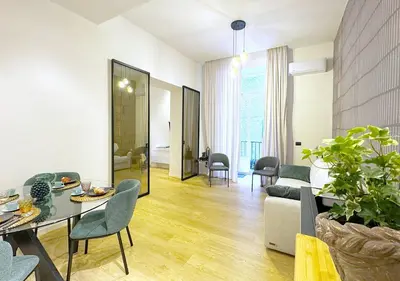 a living room with a table and chairs and a couch at Solemar Sicilia - Design Apartment Palermo in Palermo
