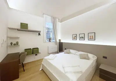 a bedroom with a bed and a desk and a window at Solemar Sicilia - Design Apartment Palermo in Palermo