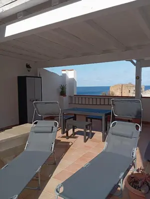a patio with a table and chairs and the ocean at La Terrazza del Mare in Palermo