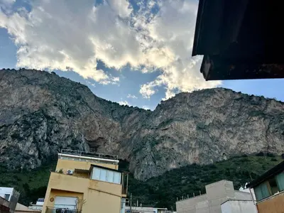 a building with a mountain in the background at La Terrazza del Mare in Palermo