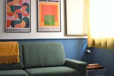 a living room with a green couch and posters at iFlat Un balcone in Cattedrale in Palermo