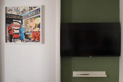 a flat screen tv on a wall with a picture at iFlat Un balcone in Cattedrale in Palermo