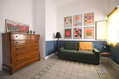 a living room with a green couch and a dresser at iFlat Un balcone in Cattedrale in Palermo