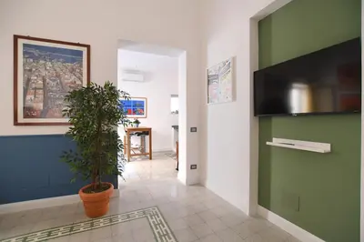 a hallway with a green wall and a potted plant at iFlat Un balcone in Cattedrale in Palermo