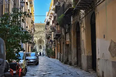 an alley with cars parked on a street with a building at iFlat Un balcone in Cattedrale in Palermo