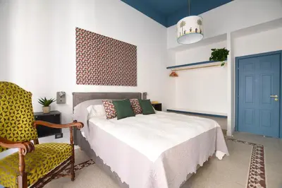 a bedroom with a bed and a chair and a blue door at iFlat Un balcone in Cattedrale in Palermo