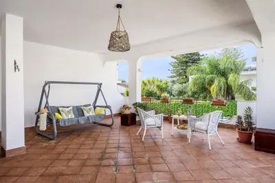a room with a porch with a swing and chairs at More Holidays Sun in Mondello
