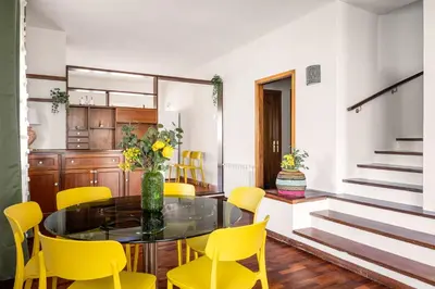 a dining room with a glass table and yellow chairs at More Holidays Sun in Mondello
