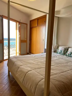 a bedroom with a bed with a view of the ocean at Finestra sul golfo in Balestrate