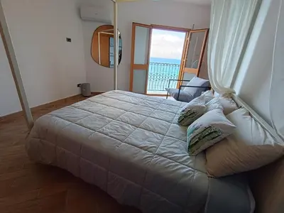 a bedroom with a bed with a view of the ocean at Finestra sul golfo in Balestrate
