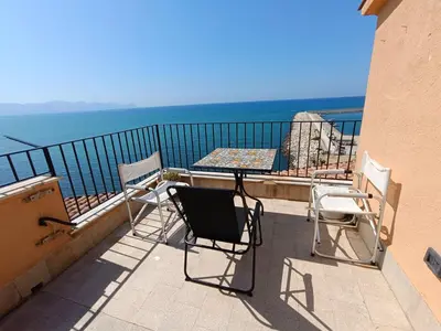 a table and chairs on a balcony overlooking the ocean at Finestra sul golfo in Balestrate