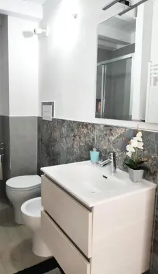a bathroom with a sink and a toilet and a mirror at Tourist House Palermo in Palermo