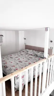 a bed in a room with a white crib at Tourist House Palermo in Palermo
