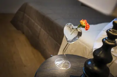 a table with a wine glass with a flower in it at BB 22 Palace in Palermo