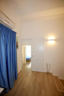 a room with a blue curtain and a door at B&B Teatro in Palermo