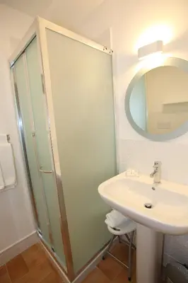 a white bathroom with a sink and a mirror at B&B Teatro in Palermo