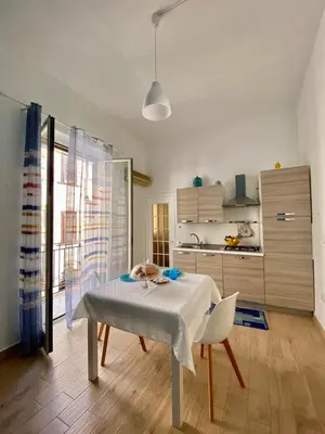 a kitchen with a table and a white table and a kitchen at Casa Vacanze Marco Polo vista mare in Trappeto