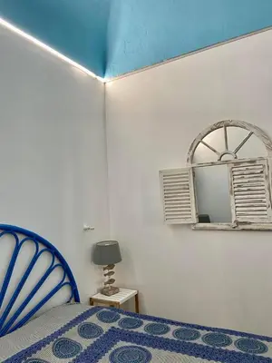 a bedroom with a blue bed and a mirror at Casa Vacanze Marco Polo vista mare in Trappeto