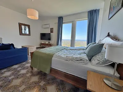 a bedroom with a large bed with a large window at The Best View Sicily Apart in Carini