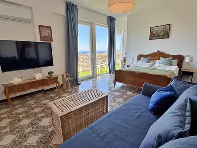 a living room with a bed and a tv and a couch at The Best View Sicily Apart in Carini