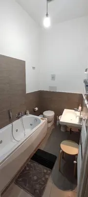 a bathroom with a tub and a toilet and a sink at Charme Rooms Palermo-By E&K in Palermo