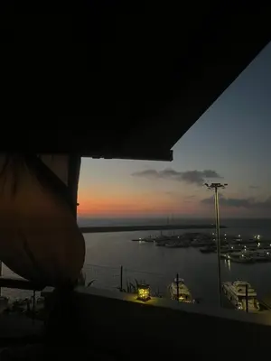 a view of a harbor at sunset from a window at Baia Marina Suite with private jacuzzi in Balestrate