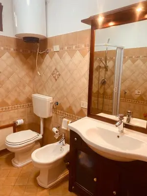a bathroom with a sink and a toilet and a mirror at Baia Marina Suite with private jacuzzi in Balestrate