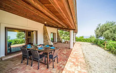 an outdoor patio with a wooden table and chairs at Nice Apartment In Collesano Pa in Lascari