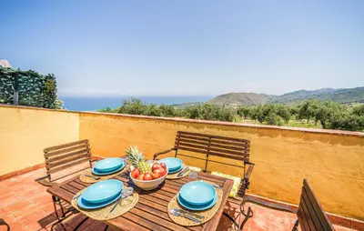 a wooden table with a bowl of fruit on a balcony at Amazing Apartment In Collesano Pa in Lascari