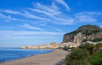 a beach with a town on a hill next to the ocean at Amazing Apartment In Collesano Pa in Lascari