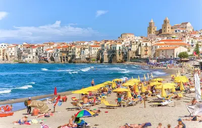 a group of people on a beach with yellow umbrellas at Amazing Apartment In Collesano Pa in Lascari