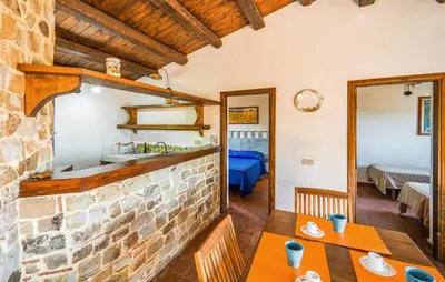 a dining room with a table and a stone wall at Amazing Apartment In Collesano Pa in Lascari