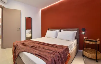 a bedroom with a bed with a red wall at Beautiful Apartment In Trappeto in Trappeto