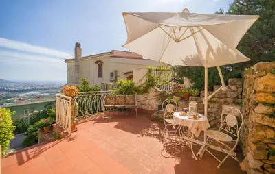 a patio with a table and an umbrella at Nice Apartment In Palermo in Palermo