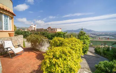 a balcony with a white chair and some bushes at Nice Apartment In Palermo in Palermo